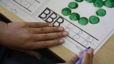 A hand with crayon practicing writing