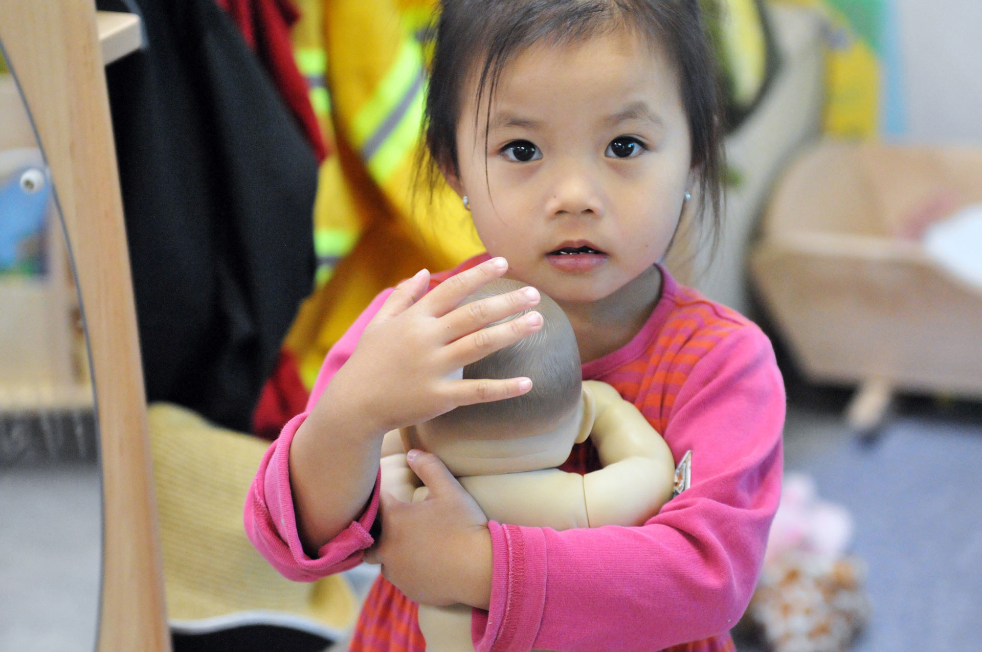 A little girl holding a doll